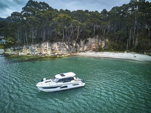 Luxury boat docked in bay with white sand beach and blue water