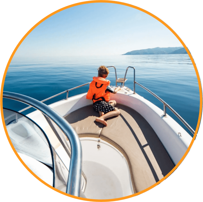 Child with life vest sitting at the front of a luxury boat