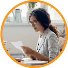 professional woman sitting at desk reading paper